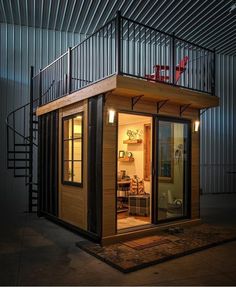 a tiny house built into the side of a building with stairs leading up to it