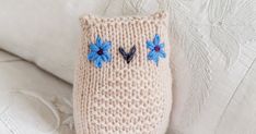 a knitted owl pillow sitting on top of a white couch