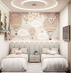 two twin beds in a bedroom with hot air balloons on the wall and ceiling lights