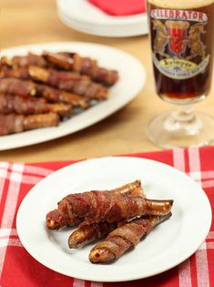 bacon wrapped in strips on a white plate next to a glass of beer and red checkered table cloth