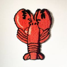 a close up of a red and black patch with a lobster on it's face