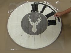 a clock made out of wood with a deer's head painted on the front