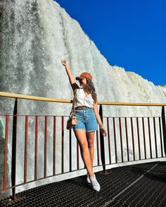 a woman taking a selfie in front of a waterfall