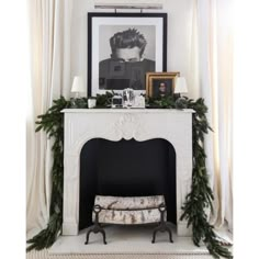 a fireplace decorated for christmas with greenery