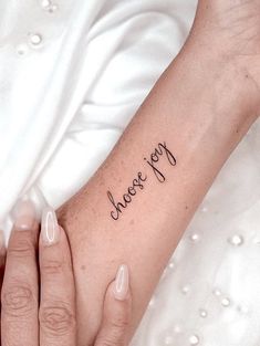 a woman's arm with a tattoo that says, happy on the left wrist