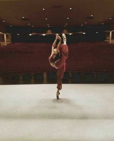 a person doing a handstand in an empty auditorium