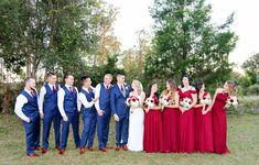 a group of people standing next to each other on top of a grass covered field