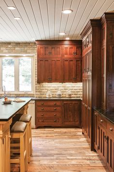 a large kitchen with wooden cabinets and counter tops, along with an island in the middle