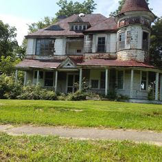 an old, run down house sits in the grass