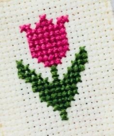 a cross stitch pattern with a pink flower on it