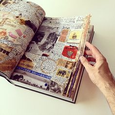 an open book with pictures and words on the pages is being held by a man's hand