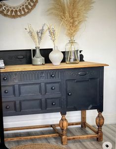 a black dresser with two vases sitting on top of it