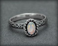 Sold Individually • MADE TO ORDER - please allow for production time • MATERIALS: sterling silver, synthetic opalITEM DETAILS :I designed this beautiful opal ring to have a vintage feel to it. With its beautiful, floral patterned band and oxidation to bring out the textures, it has a bit of a Victorian vibe. I have set a stunning synthetic opal in the color of your choice, that has fiery flashes of color. Photos don't do these opals justice. They are just gorgeous. Because it is cut to your ring Synthetic Opal, Ring Sizer, Pretty Rings, Opal Ring, Opal Rings, Choose Colors, Artisan Jewelry, Handcrafted Jewelry, Band Rings