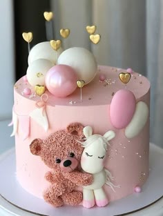 a pink cake decorated with balloons and teddy bears