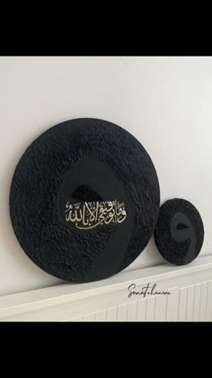 the wall is decorated with black and gold calligraphy, along with two round rugs