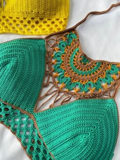 two crocheted bikinisuits laying on top of each other, one in green and the other in yellow