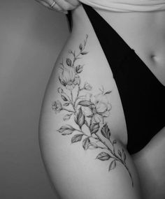 a black and white photo of a woman's stomach with flowers on the side