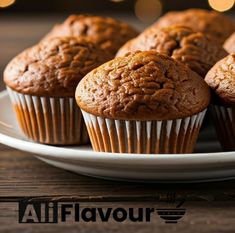 some muffins are sitting on a plate with lights in the backround