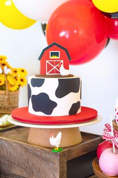 a birthday cake with a farm scene on top and balloons in the air behind it