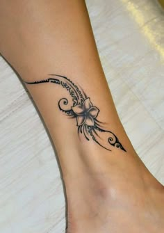 a woman's foot with a flower tattoo on the side of her leg and an arrow