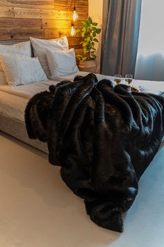 the bed is made with black fur and pillows