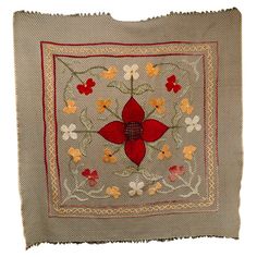 an embroidered pillow with red and yellow flowers on it