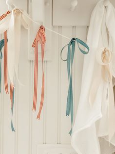 three ribbons hanging from a clothes line in front of a white wall and cupboards