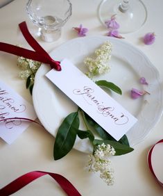 a table set with flowers and place cards for guests to write on the menus