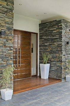 the entrance to a house with two large planters