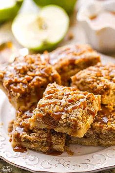 apple pie bars on a white plate with apples in the background