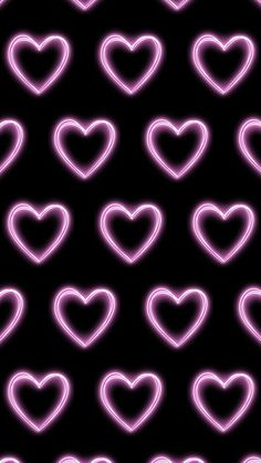 neon hearts are arranged in the shape of heart shapes on a black background with pink lights