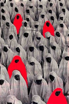 a large group of people with red hoods on their heads are standing in the middle of a crowd