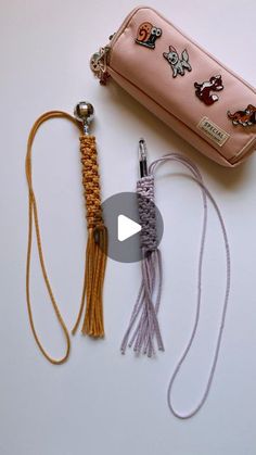 a pink purse sitting on top of a white table next to a tassell