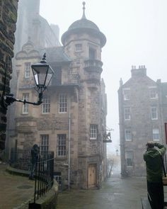 an old stone building on a foggy day