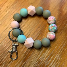 a close up of a bracelet on a table with beads and a pair of scissors