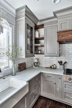 a kitchen with white cabinets and wood floors