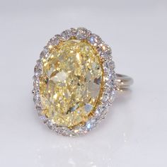 Extremely rare oval cut GIA certified 12.71 carat fancy light yellow diamond set in 18k white gold. This royal halo setting has 18 beautiful white diamonds set in a handmade ring. An absolutely magnificent ring for $225,000!!                                                    Louis XV Jewelers Jewelers of Distinction est. 2004 Founded in the traditions of exceptional quality, style, and service, Louis XV jewels are  being worn around the world. Our focus is on making sure every jewel is made with the  absolute most exquisite craftsmanship.    Nationally, Louis XV has distinguished ourselves from the other elite jewelers by popularizing the concept of 'Obtainable Extravagance.' We are purveyors of important jewelry, aggressively priced. Obtainable Extravagance illustrates our  passion to sh Canary Yellow Diamonds, Yellow Diamond Ring, Yellow Diamonds Engagement, Yellow Diamond Rings, Diamond Halo Ring, Halo Setting, Dream Engagement Rings, Canary Yellow, Buying Diamonds