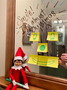 an elf is taking a selfie in front of a mirror with sticky notes on it