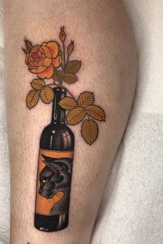 a tattoo on the leg of a woman with roses in a bottle and bull's head