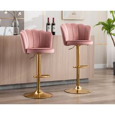 two pink velvet bar stools with gold legs