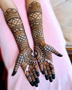 two hands with henna designs on them