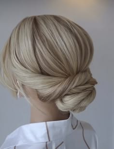 a woman with blonde hair styled into a low bun