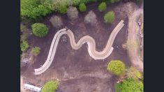 an aerial view of a winding road in the woods