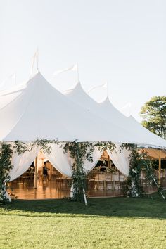 a large white tent set up with tables and chairs