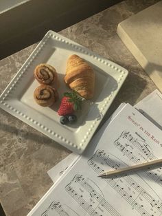 pastries on a plate with music sheets and strawberries