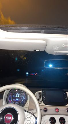 the interior of a car with its dashboard lights on and dash lights lit up at night