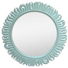 a round mirror with an intricate design on the front and sides, in light blue