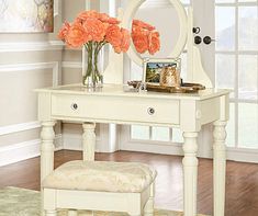 a white dressing table with flowers and a mirror