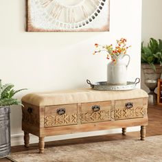 a wooden bench sitting next to a potted plant on top of a hard wood floor