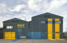 an industrial building with yellow and blue doors